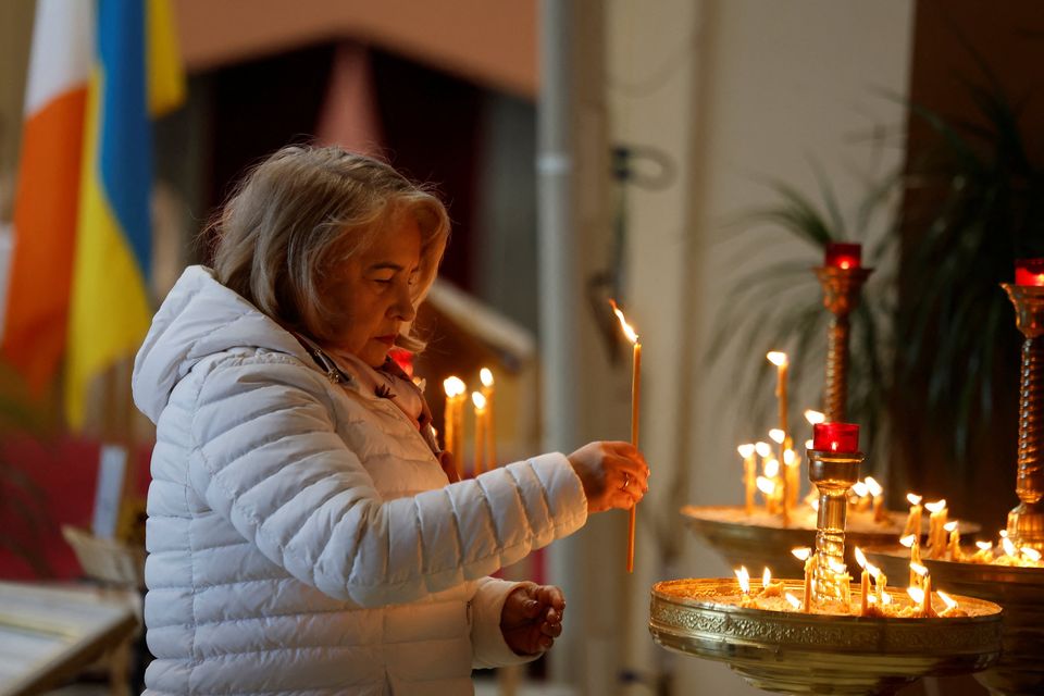 A woman lights a candle at a Ukrainian Catholic mass said by Fr Vasyl Kornitsky, held in Our Lady of Consolation church in Dublin. Photo: Reuters